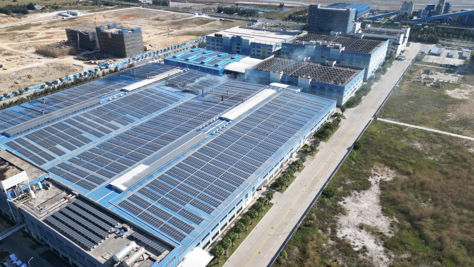 Aerial view of solar modules covering the roofs of a large factory building